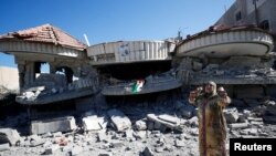 A woman gestures next to the house of jailed Palestinian assailant Muntasir al-Shalabi, after it was blown up by Israeli forces, in Turmus Aya, near Ramallah in the Israeli-occupied West Bank, July 8, 2021. 