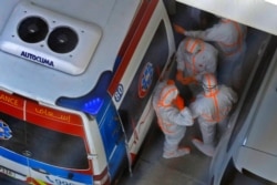 An emergency medical response team arrives at the Crowne Plaza hotel at Yas Island Abu Dhabi, Feb. 28, 2020. Two Italian cyclists participating in the UAE Tour tested positive for COVID-19, prompting the cancellation of the final stages of the event.