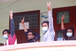 Min Nyi Nyi Kon, center left, Pyae Sone Aung, right, Ye Win Tun, left, and Saw Oak Kar Oo, center right, show a salute of protest during their court appearance in Mandalay, Myanmar, Feb. 5, 2021.