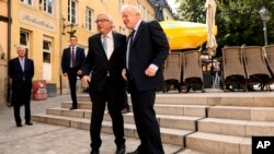 European Commission President Jean-Claude Juncker, left, shakes hands with British Prime Minister Boris Johnson prior to a meeting at a restaurant in Luxembourg, Sept. 16, 2019.