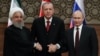 FILE - Iran's President Hassan Rouhani, from left, Turkey's President Recep Tayyip Erdogan and Russia's President Vladimir Putin shake hands after a joint press conference as part of a tripartite summit on Syria, in Ankara, April 4, 2018.