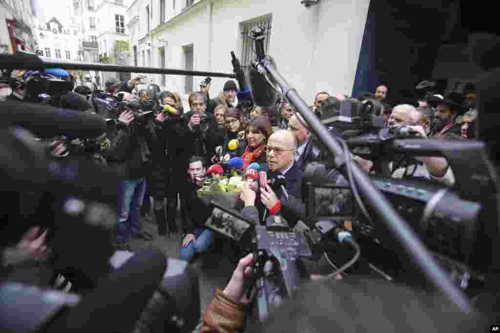 French Interior Minister Bernard Cazeneuve and Paris Mayor Anne Hidalgo address reporters after visiting the Jewish school of the Rue Pavee, in the heart of the Paris Jewish quarter, Jan. 12, 2015.
