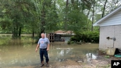 Miguel Flores Sr. stands in his flooded backyard outside his home in the northeast Houston neighborhood of Kingwood on May 4, 2024. Officials said the area had about four months' worth of rain in about a week’s time.
