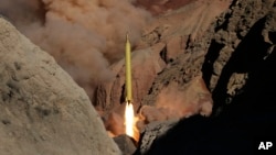 FILE - In this photo obtained from the Iranian Fars News Agency, a Qadr H long-range ballistic surface-to-surface missile is fired by Iran's Revolutionary Guard, during a maneuver, in an undisclosed location in Iran, March 9, 2016.