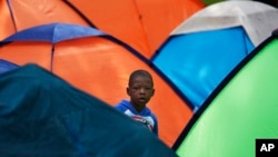 Un niño observa desde un campamento en la plaza de Giordano Bruno, en Ciudad de México, el 18 de mayo de 2023. El pequeño forma parte de un grupo de migrantes que aspira a llegar a la frontera con EEUU.