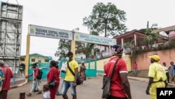 FILE - People walk by the entrance to Yaounde General Hospital in Yaounde, Cameroon, March 6, 2020.