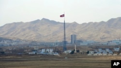 FILE - North Korea's flag flies on a tower high above the village of Ki Jong Dong, as seen from an observation post in Panmunjom, March 25, 2012.