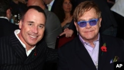 FILE - Sir Elton John (R) and David Furnish are seen at an awards ceremony in London, Nov. 5, 2012.