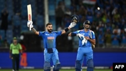 India's Virat Kohli (L) standing next to his teammate Axar Patel celebrates after scoring a century (100 runs) and their team's win at the end of the ICC Champions Trophy one-day international (ODI) cricket match between Pakistan and India at the Dubai In