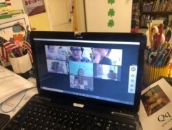 Kindergarten children taking online lessons. Sometimes parents have to help with the technology. (Eunjung Cho/VOA)