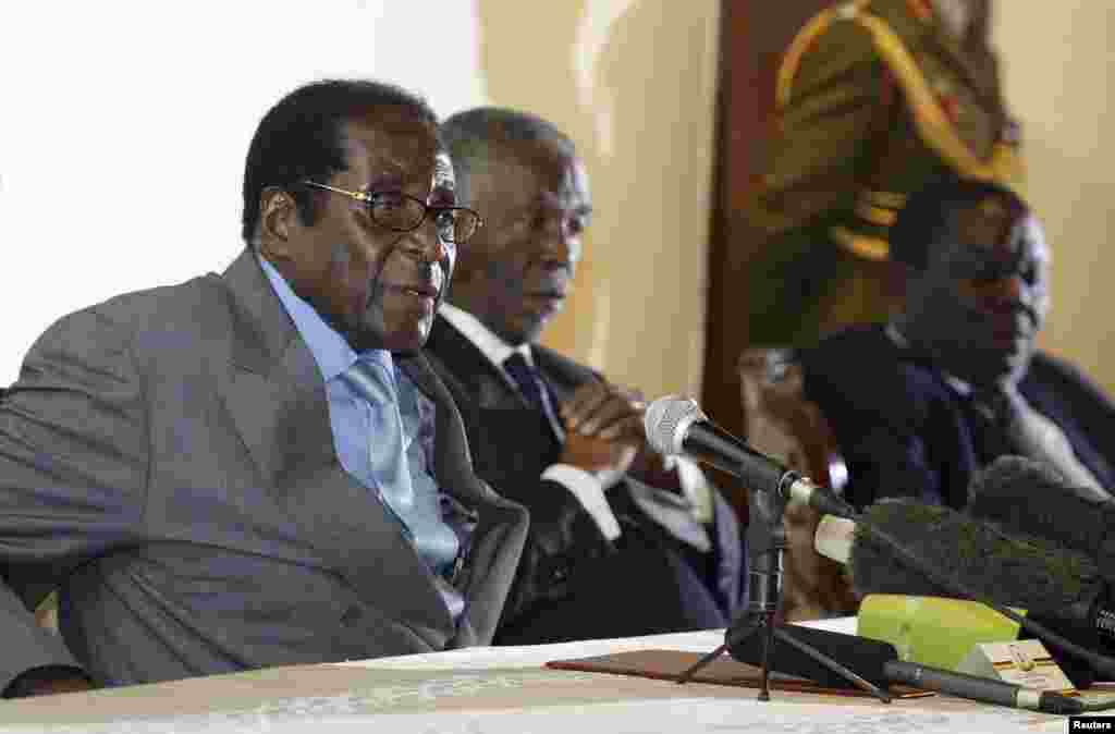 Zimbabwe's President Robert Mugabe (L) addresses the media as South Africa's President Thabo Mbeki (C) and leader of Zimbabwe's main opposition Movement for Democratic Change (MDC) Morgan Tsvangirai listen at Harare's Rainbow Towers Hotel July 21, 2008.
