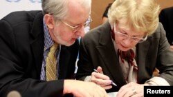 Karen Koning Abuzayd, member of the International Commission of Inquiry on Syria for the United Nations Human Rights Council talks to commission chairperson Paulo Pinheiro before a news conference on the presentation of their latest report at the U.N.