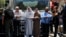 Palestinians stand next to a police barricade as they wait for the compound known to Muslims as Noble Sanctuary and to Jews as Temple Mount to be reopened, in Jerusalem's Old City, July 16, 2017.
