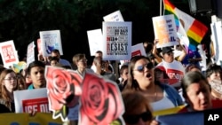FILE - Protesters march through downtown Phoenix, May 1, 2017. Immigrant and union groups marched in cities across the United States on Monday to mark May Day and protest against President Donald Trump's efforts to boost deportations. 