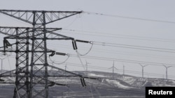 Torres eléctricas y turbinas de viento de la corporacion china State Grid se observan en una foto en la provincia de Hebei.