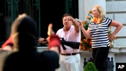 Armed homeowners standing in front their house along Portland Place confront protesters marching to St. Louis Mayor Lyda Krewson's house, June 28, 2020, in the Central West End of St. Louis. 