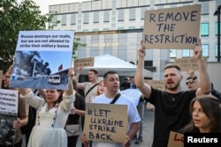 Ukrainian activists attend a rally in front of the U.S. Embassy in Kyiv, demanding to remove the restriction to use foreign weapons against Russia on its territory, May 26, 2024.