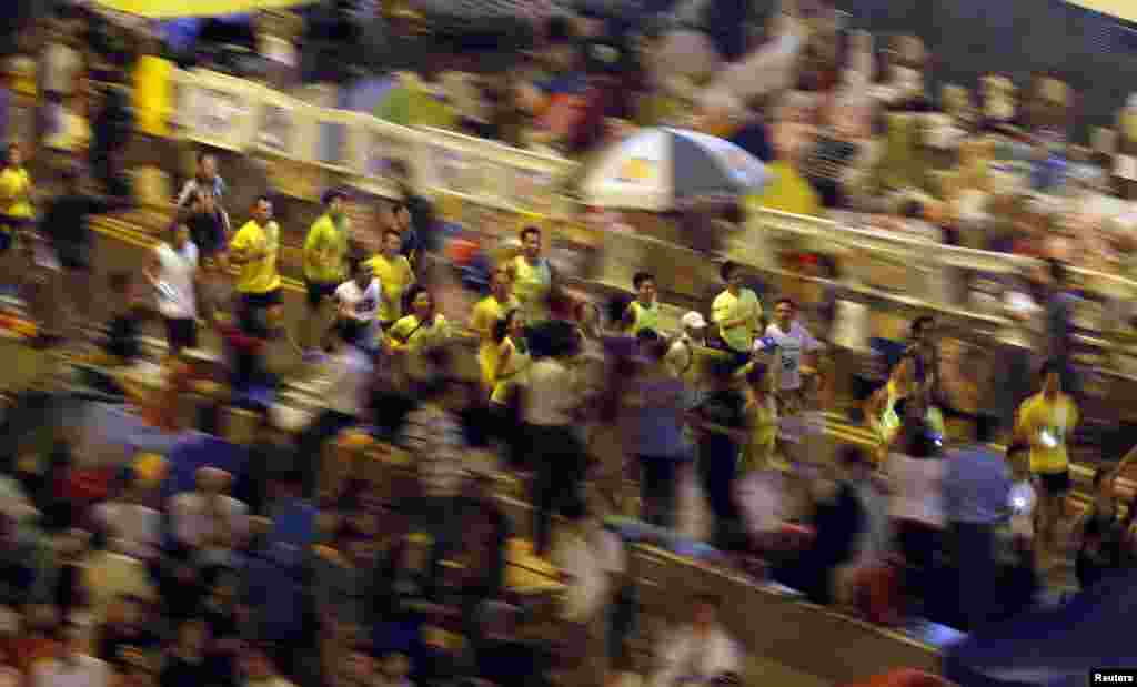 Runners participate in a 5km run in support of pro-democracy demonstrators near a blocked area outside the government headquarters, in Hong Kong, Oct. 16, 2014. 