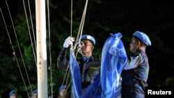 FILE - U.N. peacekeepers lower the U.N. flag during an event marking an end of the Mission of United Nations for the Stabilization in Haiti (MINUSTAH), at the U.N. headquarters in Port-au-Prince, Haiti, Oct. 5, 2017. 