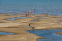 FILE - Sightseers play on a sandbar in the Mekong River in Nakhon Phanom province, northeastern Thailand, Dec. 4, 2019.