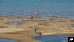 FILE - Sightseers play on a sandbar in the Mekong River in Nakhon Phanom province, northeastern Thailand, Dec. 4, 2019. 