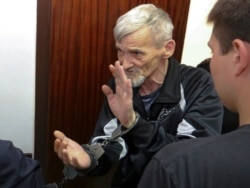Russian historian Yury Dmitriyev is escorted into a court room in the city of Petrozavodsk, northwestern Russia in Petrozavodsk, Russia, Thursday, June 28, 2018.