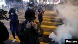 Anti-government protesters react to tear gas during a protest on Christmas Eve at Tsim Sha Tsui in Hong Kong, China, December 24, 2019. (REUTERS/Tyrone Siu)