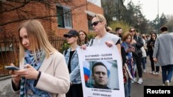 ইতালির মিলান শহরে রাশিয়ার কনসুলেটের বাইরে এক নারী প্রয়াত রুশ বিরোধী নেতা অ্যালেক্সে নাভালনির ছবি হাঁতে নির্বাচনের প্রতিবাদ জানাচ্ছেন। ফটোঃ ১৭ মার্চ, ২০২৪।