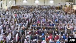 Para pekerja sibuk melinting tembakau di area kerjanya masing-amsing yang hanya dibatasi oleh plastik sebagai bagian dari pencegahan COVID-19 di Pabrik Rokok Gudang Baru di Malang, Jaw Timu, pada 11 Juli 2020. (Photo by AFP/Aman Rochman)