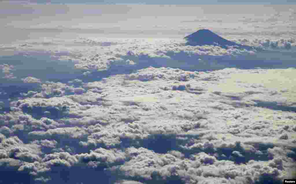 Japan's Mount Fuji, surrounded by clouds, is seen from an airplane
