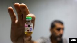 A worker shows a vial containing a polio vaccine provided with support from UNICEF to the Gaza Strip through the Karm Abu Salem crossing, also known as Kerem Shalom, at a depot belonging to Gaza's Health Ministry, Aug. 25, 2024.