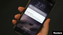 A test text message of the Presidential Alert, National Wireless Emergency Alert System is seen on a mobile phone in New York City, New York, Oct. 3, 2018.