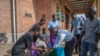 Parishoners wash hands as a preventive measure against the spred of the COVID-19 on the last day of full gatherings at the Saint Don Bosco Catholic Parish in Lilongwe, March 22, 2020.
