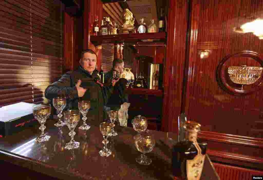 A man gestures behind the interior bar of the Mezhyhirya residence of Viktor Yanukovich in the village Novi Petrivtsi, Feb. 22, 2014. 