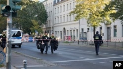 Sejumlah anggota kepolisian Jerman berjaga di depan kompleks komunitas Kahal adass Jisroel, yang mencakup sebuah sinagoge dan taman kanak-kanak, di Berlin, pada 18 Oktober 2023. (Foto: AP/Markus Schreiber) 