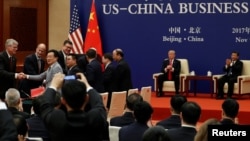 China's President Xi Jinping and U.S. President Donald Trump witness U.S. and Chinese business leaders signing trade deals at the Great Hall of the People in Beijing, China, Nov. 9, 2017. 