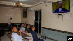 People watch news about the delayed election on a television in Mogadishu, Somalia, Jan. 28, 2021.