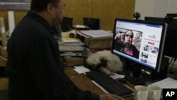 Chinese dissident artist Ai Weiwei plays a video clip he uploaded on Youtube on a computer in Beijing, China, October 25, 2012.