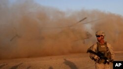 FILE - A U.S. Marine takes part during a training session for Afghan army commandos in Shorab military camp in Helmand province, Afghanistan, Aug. 27, 2017.