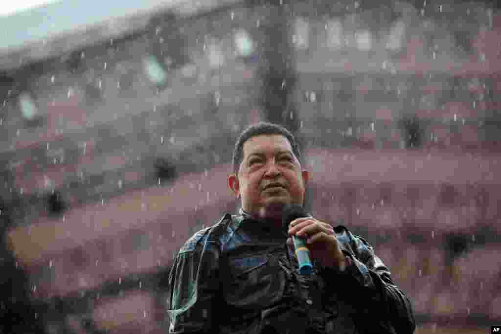 Hugo Chavez holds a microphone under pouring rain during his closing campaign rally in Caracas, October 4, 2012. 