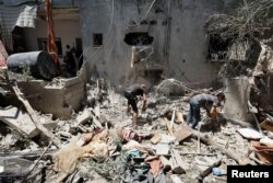 Warga Palestina memeriksa sebuah rumah yang terkena serangan Israel, di tengah konflik Israel-Hamas, di Deir Al-Balah di Jalur Gaza tengah, 15 Juli 2024. (Foto: REUTERS/Ramadan Abed)