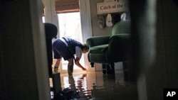 Sherry Rose measures the water level in her home as floodwaters slowly rise in Holly Grove, Arkansas, May 10, 2011