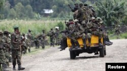 M23 rebel fighters sit on a truck as they prepare to withdraw near the town of Sake, 42 kilometers west of Goma in eastern Congo, November 30, 2012.