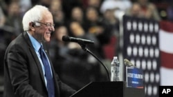 Democratic presidential candidate Bernie Sanders smiles as a bird lands on his podium during a campaign speech in Portland, Oregon, March 25, 2016.