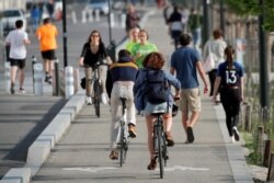 FILE - Residents enjoy the weather despite an ongoing lockdown imposed to slow the spread of the coronavirus, in Nantes, France, April 23, 2020.