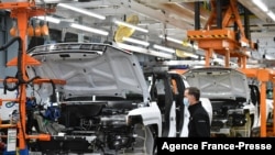 FILE - GMC Hummer EVs are seen on an assembly line at the General Motors Factory ZERO electric vehicle assembly plant in Detroit, Michigan, Nov. 17, 2021.