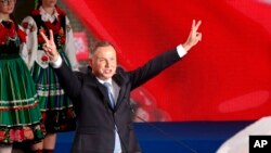 Presiden Polandia Andrzej Duda menunjukkan tanda kemenangan setelah pemungutan suara usai di Lowicz, Polandia, 28 Juni 2020.