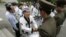FILE - Korean-American taekwondo grandmaster Jung Woo-jin, center, shakes hands with North Korean border soldiers as he offers a peace gesture of taekwondo "dobok" robes on the North Korean side of the DMZ line outside Panmunjom, May 19, 2006.