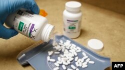 Seorang petugas tengah memperlihatkan pil hydroxychloroquine di Rock Canyon Pharmacy, Provo, Utah, 20 Mei 2020. (Foto: dok).