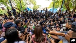 สื่อมวลชนหลายแขนงขณะสัมภาษณ์แพทองธาร ชินวัตร ที่คูหาเลือกตั้งในกรุงเทพมหานคร วันที่ 14 พฤษภาคม 2023 (ที่มา: AP)